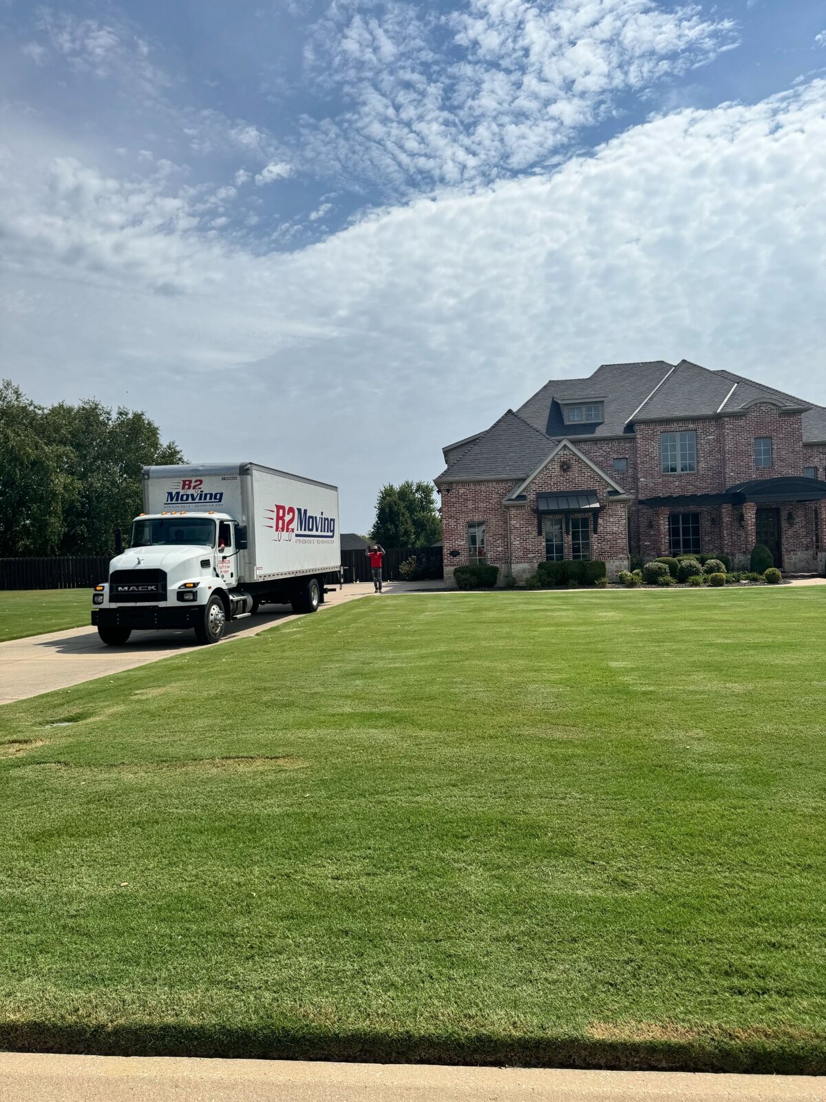 B2 Moving truck positioned in the driveway of a large Bentonville residence