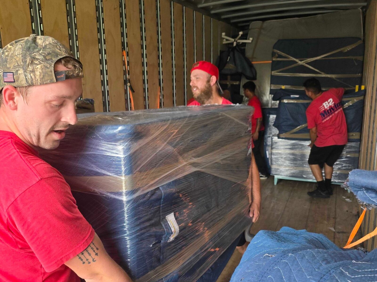 Dakota and Joe unloading protected furniture at the destination on a Springdale-to-Cave Springs move
