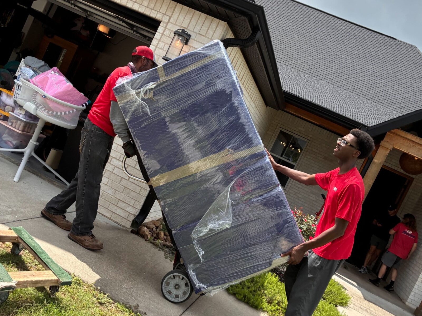 Dolph and Kevin guiding a padded and stretch-wrapped refrigerator during a Springdale load